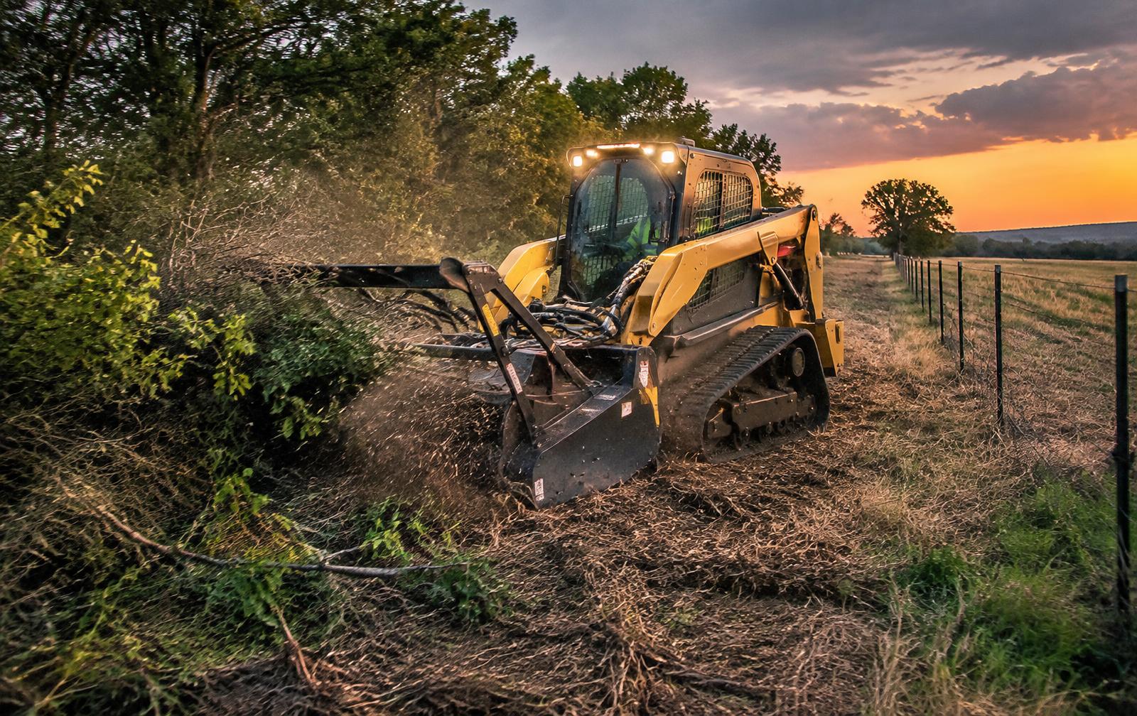 Skid steer clearing an Oklahoma fence line