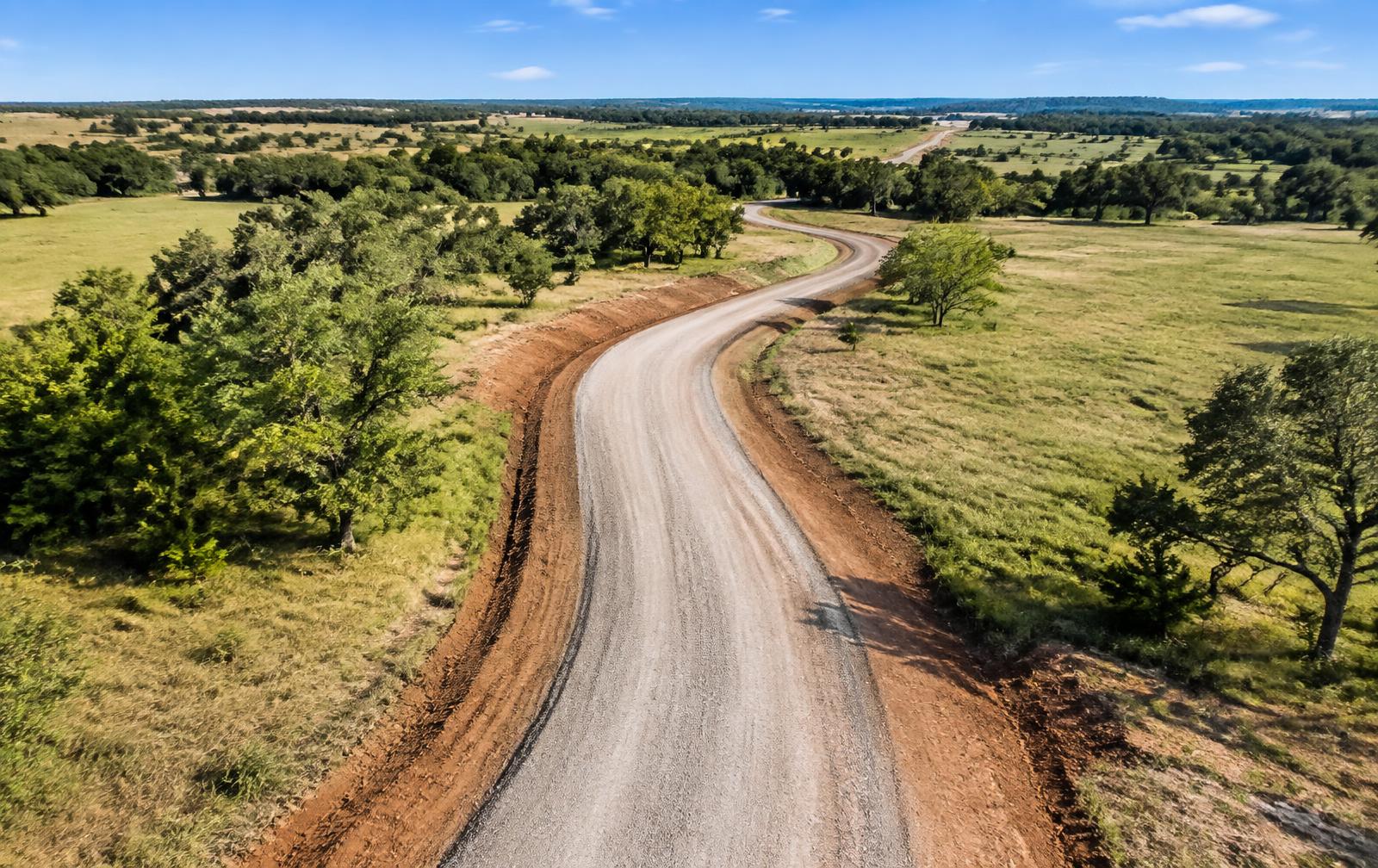 Finished gravel driveway winding through Oklahoma ranch land